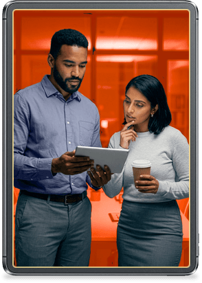 Two coworkers reviewing information on a tablet